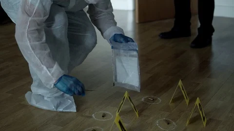 Forensic officer collecting a bullet casing as a piece of evidence Stock Footage 110714073