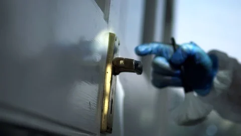 Forensic scientist dusting a door handle for fingerprints at crime scene Stock Footage 110714296