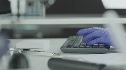 Forensic Scientist Inputs Information into a Computer Using a Keyboard Stock Footage 208708837