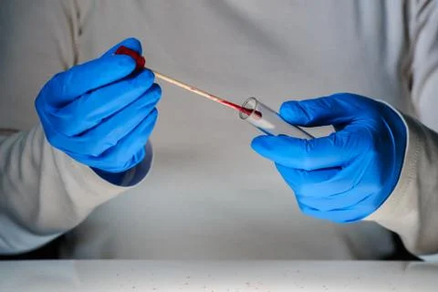 Forensic technician taking DNA sample from blood stain Stock Photos