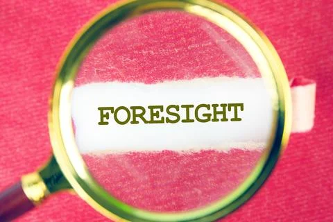 FORESIGHT word was found using a magnifying glass under a piece of paper Stock Photos
