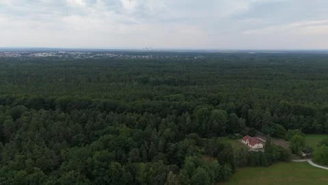 Forest and distant house under a broad cloudy Saxony sky Stockbeeldmateriaal 340646998