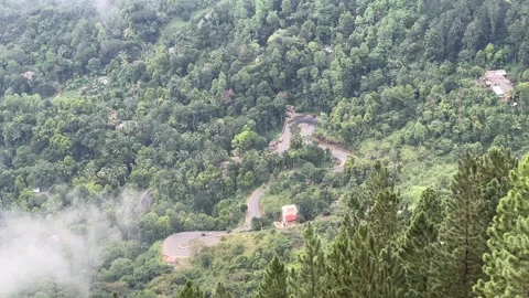 Forest and mountain road with small car on distance from Ambuluwawa tower Video stock 261576982
