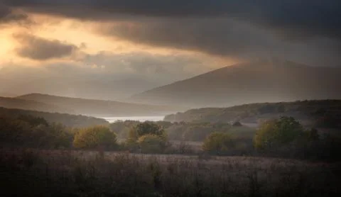 Forest and mountains in the clouds at sunset Stock Photos