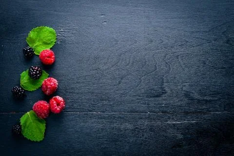 Forest berry. Raspberry, blackberry, mint. On a wooden background. Top view.  Stock Photos