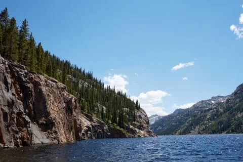 Forest with cliffs by mountain lake Stock Photos