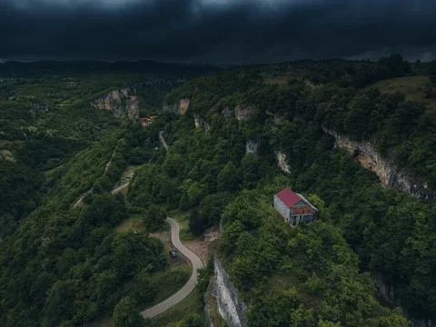 Forest covered gorge and house on a rock pillar, cliff house on top, aerial.. Stock Photos