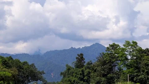 Forest-Covered Mountain Range Beneath Dramatic Clouds Video stock 346236514