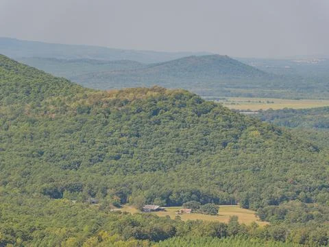 Forest covered mountain ridge with distant hills and valley Stock Photos