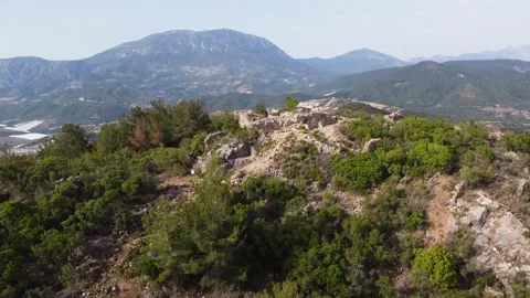 Forest-covered mountain top with a man standing at the peak Stock Footage 237511188