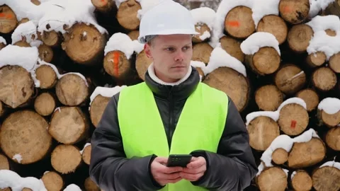 Forest engineer wearing safety helmet and protective vest works in forest with Stock Footage 231047824