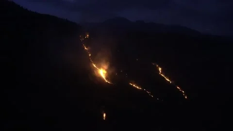 Forest fire glowing through night mountainscape. Stock Footage 316358479
