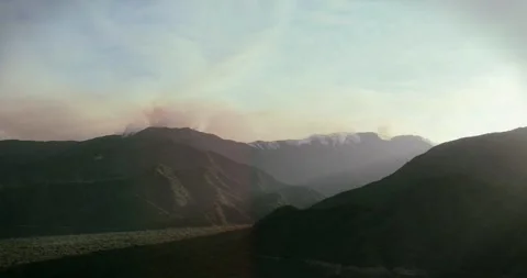 Forest Fire in the High Mountains at Sunset Captured in Time-Lapse Drone Footage Stock Footage 297527897