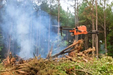 In the forest, fire services are using a drone to follow the fire into the trees Stock Photos