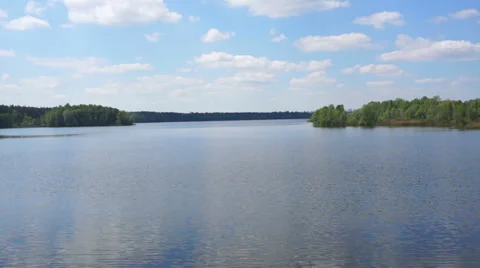 Forest lake and white clouds on blue sky. Timelapse. Stock-Footage 37974280