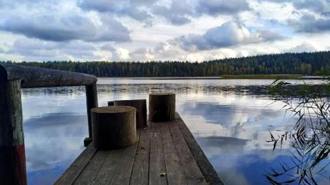 Forest lake with clouds reflecting in it. Calm autumn landscape Stock Photos