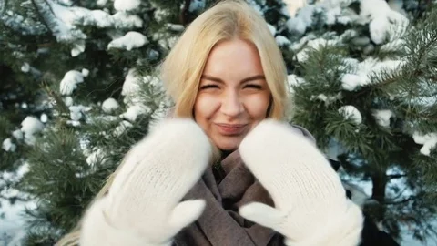 In the forest, she waves her hands in mittens and sends kisses Stock Footage 70690460