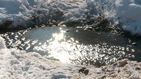 A forest stream on a sunny day in the middle of the snow in spring Stockbeeldmateriaal 336848508