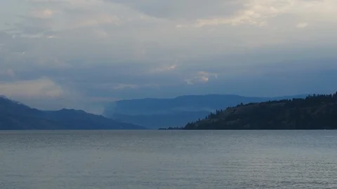 Forest time lapse mid day burning trees on a mountain lake view 4k. Stock Footage 96533111