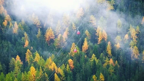 Forest trees with clouds and mist fog  and red ski lift in Dolomites 库存影片 86289260