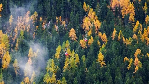 Forest trees with clouds and mist fog  and red ski lift in Dolomites 库存影片 86289691