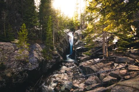 Forest waterfall during sunset. Stock Photos