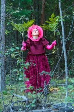 The forest witch in purple clothes performs an magical ritual with a fern. Foto stock