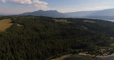 Forested Beach Front Area with Large Mountains in Background Video stock 93367934