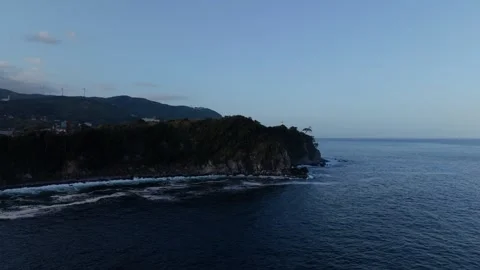 Forested headland with a small lighthouse jutting into the sea in Higashiizu Video stock 345183087
