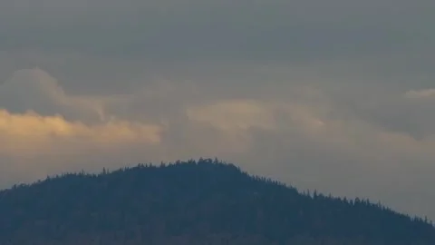 Forested Mountain Peak at Sunset with Dramatic Clouds Stock Footage 325476552