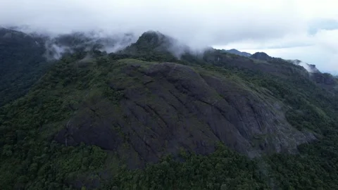 Forested Mountain Range with Dramatic Rock Face and Lingering Clouds Stock Footage 312656632