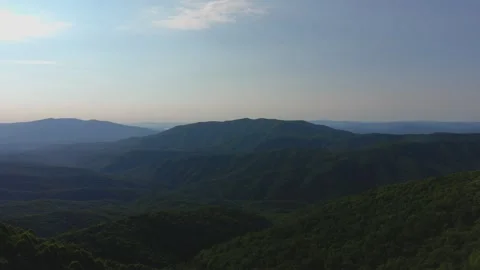 Forested Mountain Range with Rolling Hills Stock Footage 328964562
