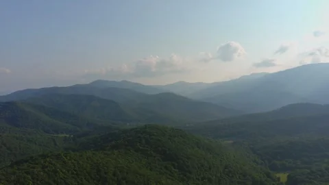 Forested Mountain Range with Rolling Hills Stock Footage 328964644
