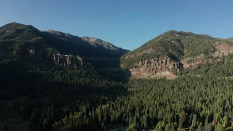 Forested mountain valley and cliffs aerial at golden hour Colorado Stock-Footage 348022305