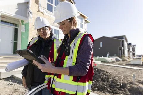 Forewoman and engineer using digital tablet at construction site Stock Photos