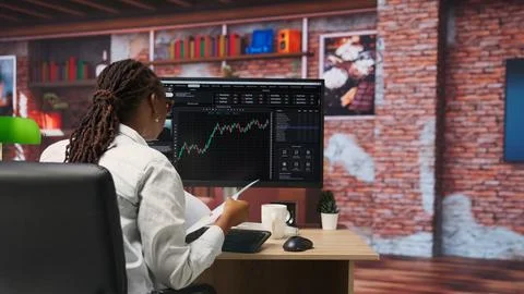 Forex trader browsing though stock exchange portfolio pages at computer desk Stock-Fotos