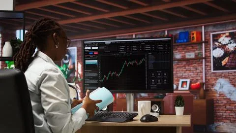 Forex trader browsing though stock exchange portfolio pages at computer desk Stock-Fotos