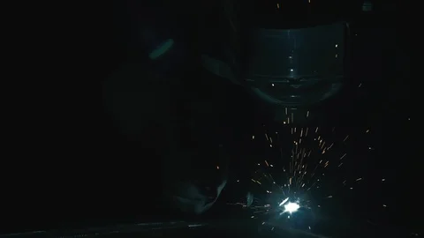 Forge workshop. Smithy. Worker in a welding hood helmet welds a part by electric Stock Footage 121121110