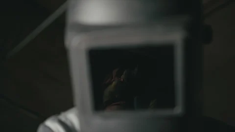 Forge workshop. Smithy. Worker in a welding hood helmet welds a part by electric Stock Footage 121939904