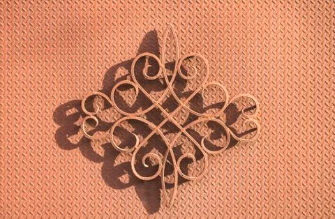 Forged decorative element with shadow on an iron background. Stock Photos
