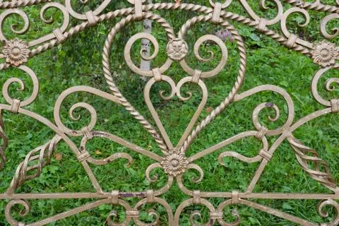 Forged elements on a garden bench in the shape of a heart.Garden wrought iron 库存照片