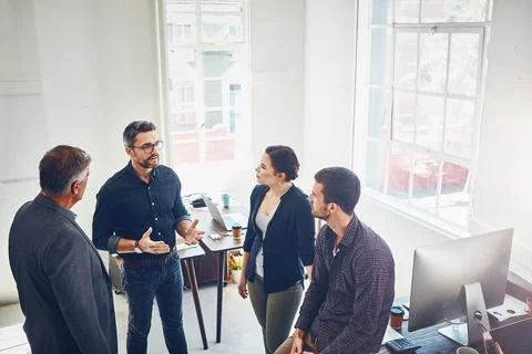 Forget quality, aim now to get a quantity of answers. a group of designers Stock Photos