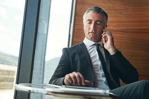 Forging business relationships over the phone. a businessman answering a Stock Photos