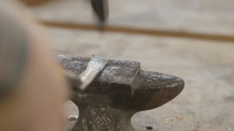 Forging a hot bearing with a hammer. a blacksmith makes a chisel from a beari Stock Footage 140323234