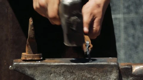 Forging hot metal in smithy. Blacksmith manually forging hot metal on the anv Видео 110836541