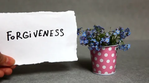 Forgiveness - word on gray background with blue flowers Vídeos de archivo 76324801