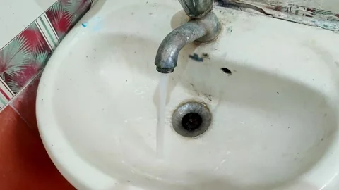 A forgotten tap left running, with water overflowing from a dirty tap into .. Video stock 329313324