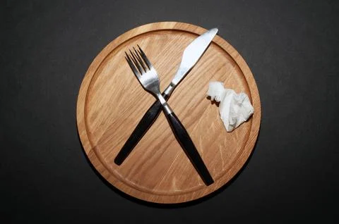 Fork and knife. Black kitchen utensils placed on a wooden table. Top view Stock Photos
