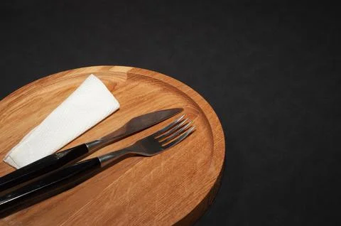 Fork and knife. Black kitchen utensils placed on a wooden table. Top view Stock Photos