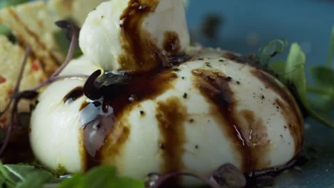 Fork and knife cuts soft cheese with drops of soy sauce herbs from which juice Stock Footage 131232935